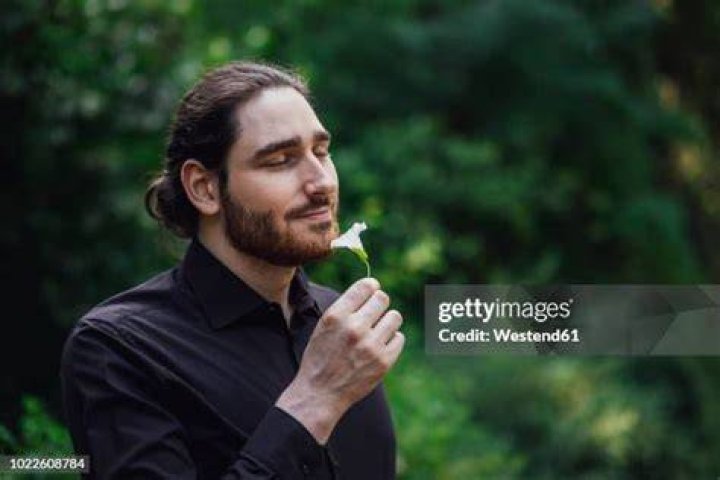 a man smelling a flower