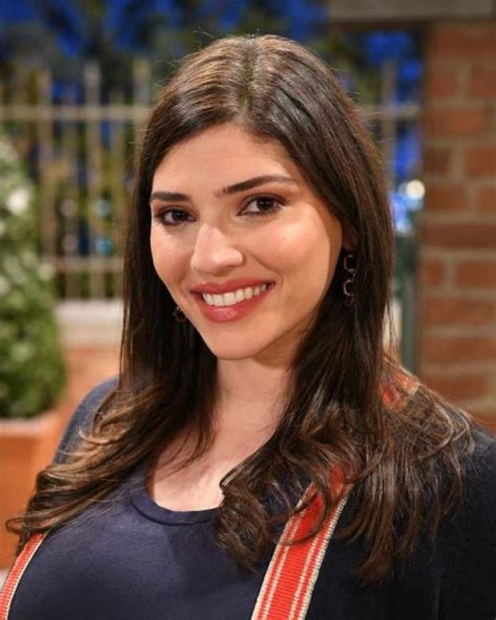 Amanda Setton smiling in front of a white background