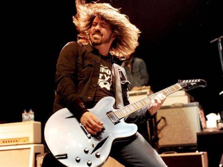 Dave Grohl playing guitar and Taylor Hawkins drumming and Hawkins singing while Grohl drums at Lollapalooza Chile 2022.