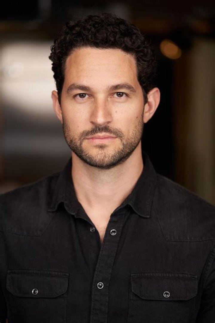 Fernando Belo as Sebastian and Minka Kelly as Samantha in Euphoria Season 2. Samantha wears and tan-colored dress and Sebastian wears a suit.