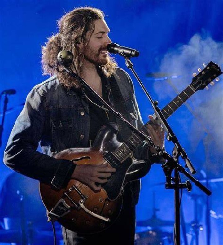 Hozier singing, playing guitar on stage