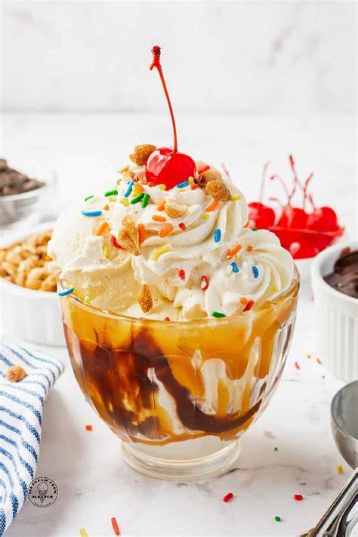 Image of Sundae on a blue background with sprinkles and a spoon.