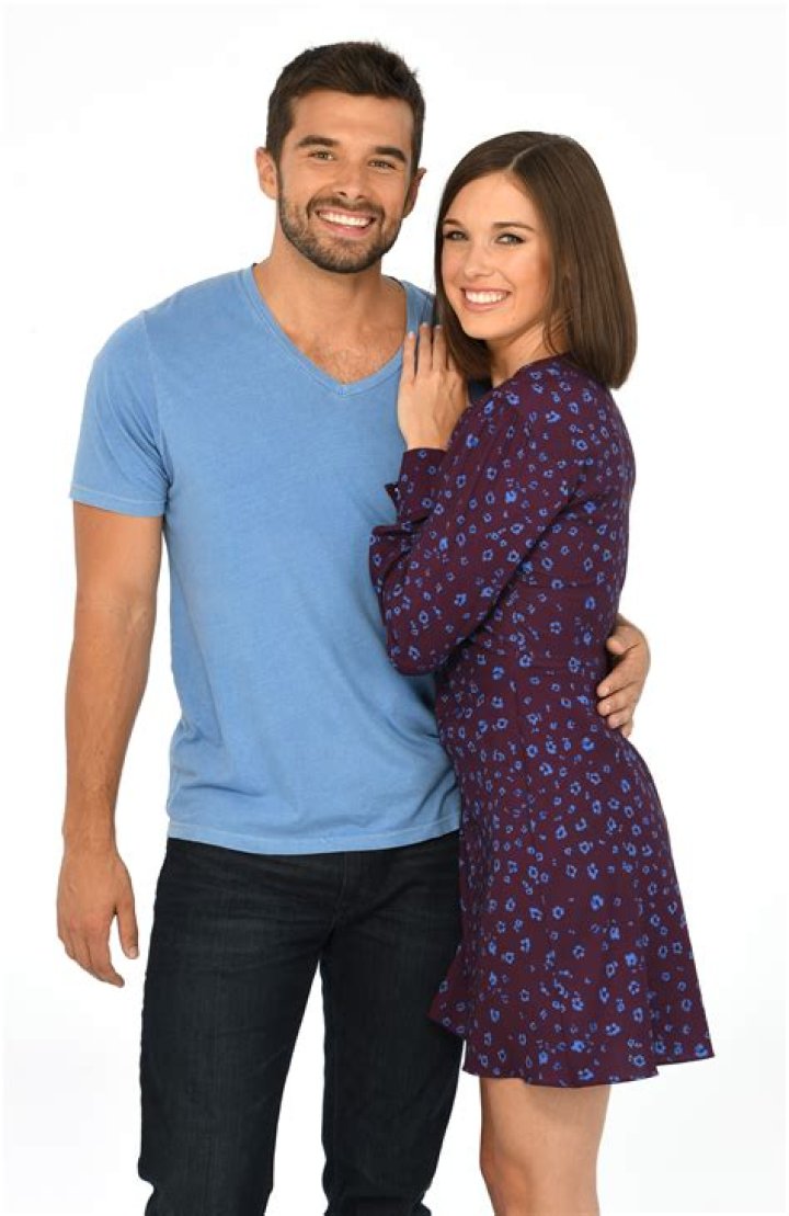 Josh Swickard and Katelyn MacMullen sitting on a couch facing each other on the set of 'General Hospital